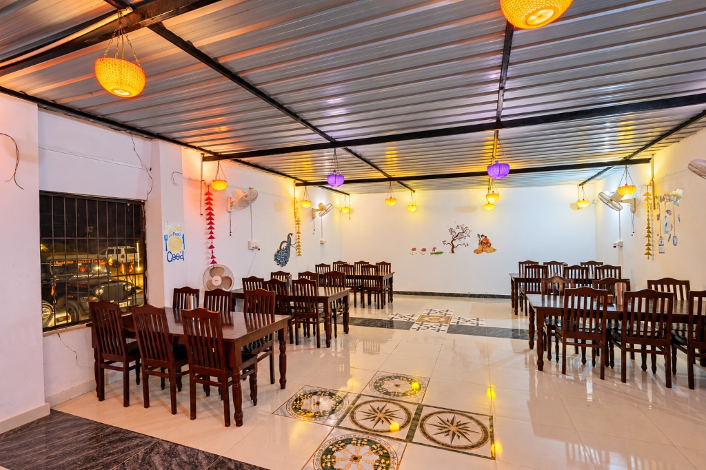 Spacious indoor dining hall with polished wooden tables and woven hanging lanterns