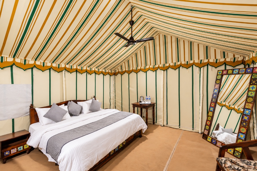 Handcrafted wooden furnishings and artisanal hand-painted standing mirror in tent suite